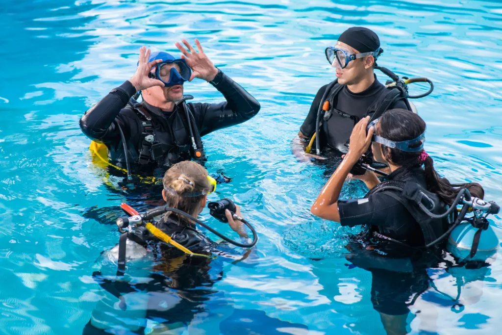 Diving instructor teaches how to attach the mask for students - Bali diving courses