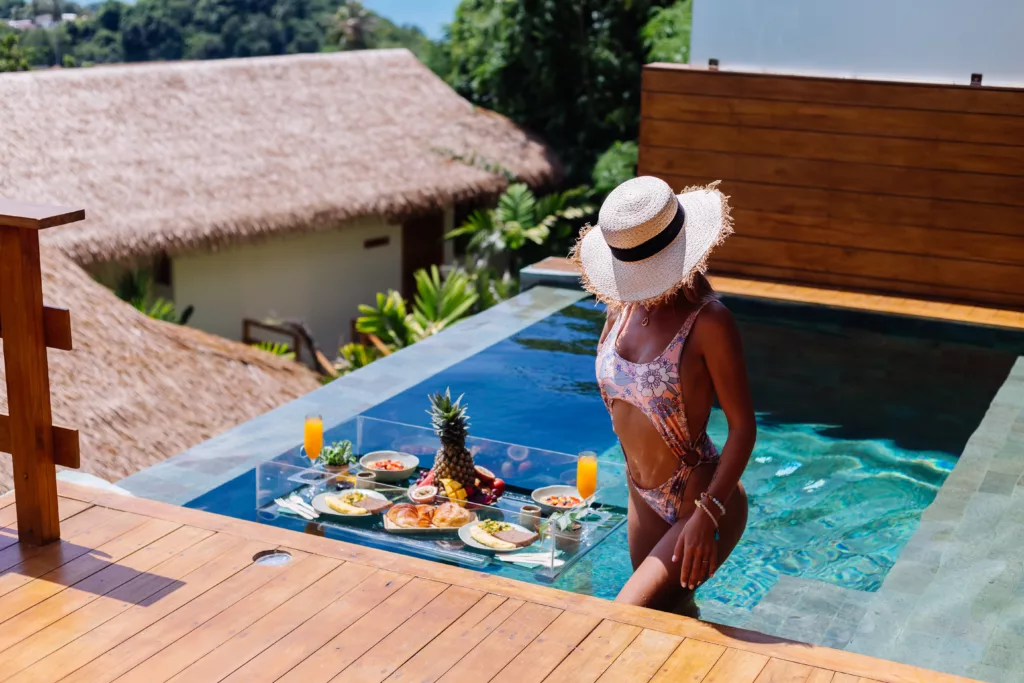 beautiful caucasian tanned woman bikini straw hat with floating breakfast amazing luxury bali style villa sunny day by swimming pool tropical background