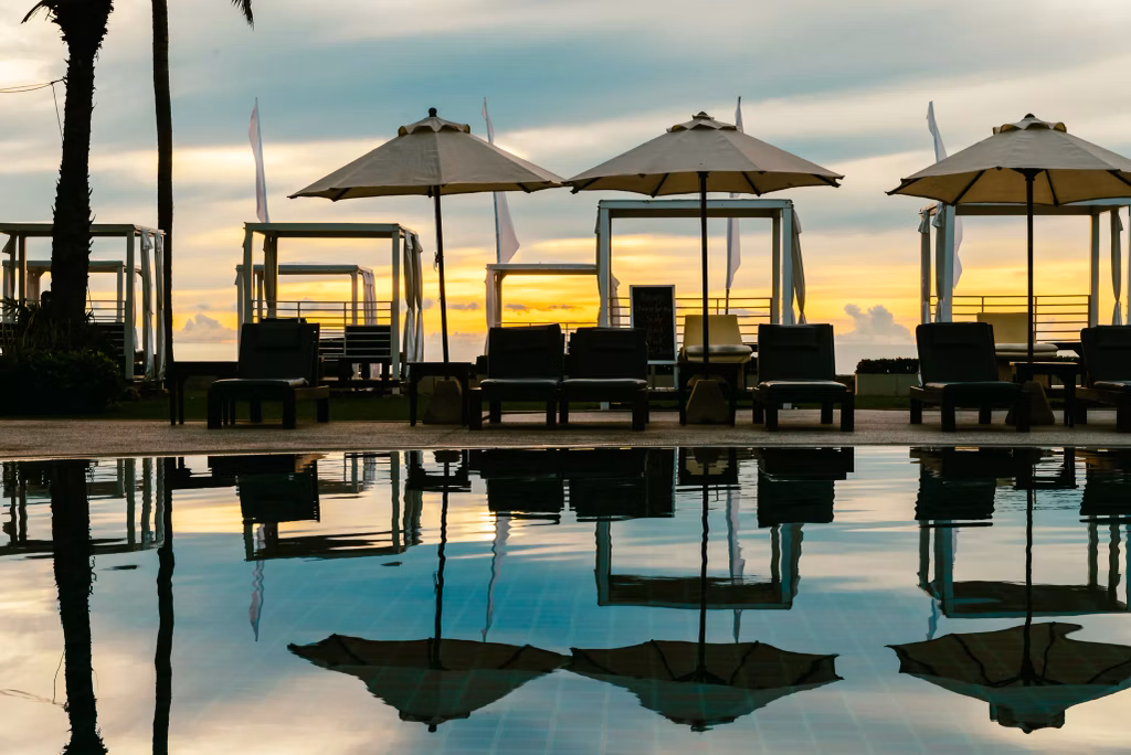 Silhouette palm tree with umbrella and chair in the luxury hotel - Bali Dive Center