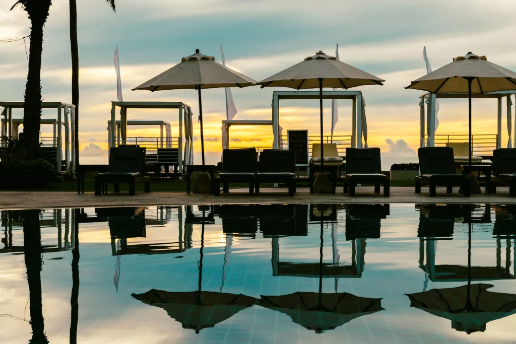 Silhouette palm tree with umbrella and chair in the luxury hotel - Bali Dive Center