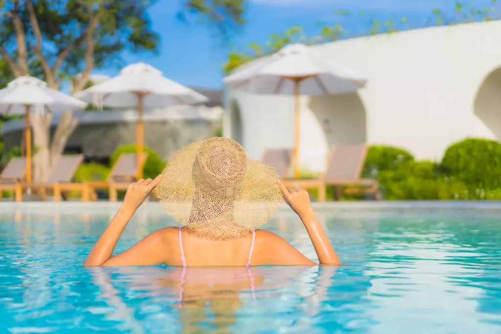 Portrait beautiful young asian woman relax leisure around outdoor swimming pool with sea beach ocean view in vacation travel - bali dive resort