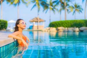 Portrait beautiful young asian woman relax smile leisure around outdoor swimming pool with sea ocean view - Bali Dive Resort