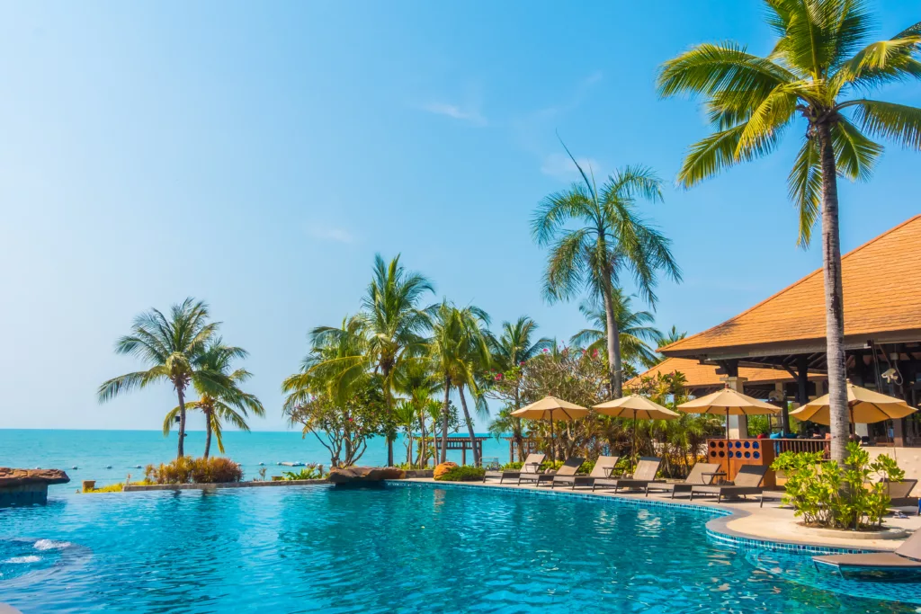 Beautiful luxury Swimming pool with palm tree and sea background in hotel pool Bali dive resort 