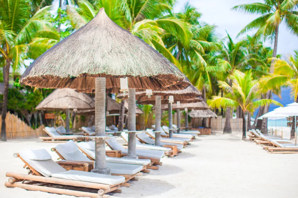 Beach chairs on exotic tropical white sandy beach - Bali dive resort