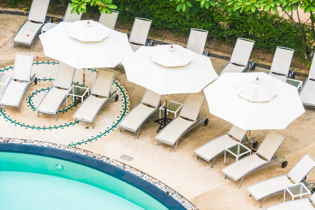 Outdoor swimming pool with umbrella and chair in hotel resort - Bali Dive Resort