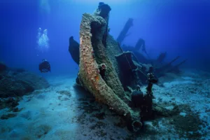 A scuba diver explores a sunken shipwreck at the Boga Wreck - magic dive sites